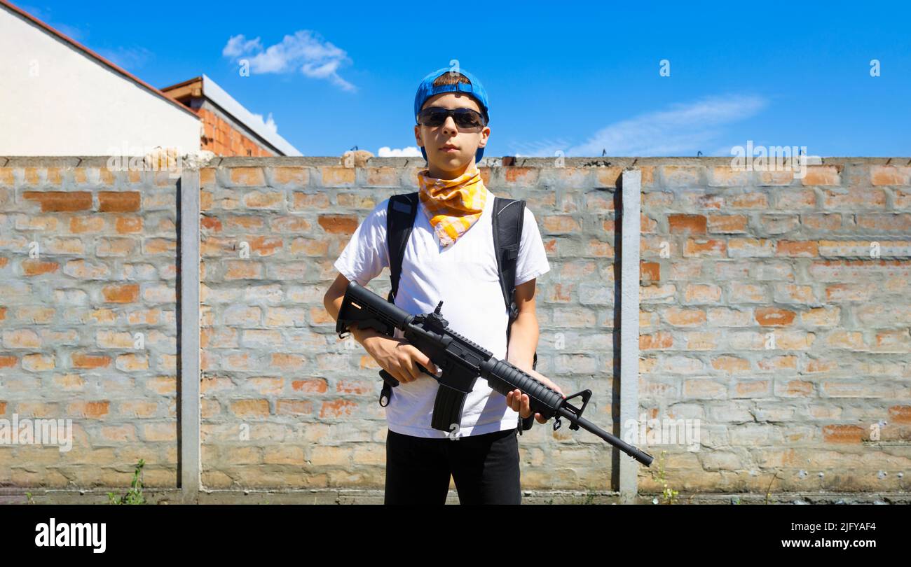 Junger Kaukasusmann mit einem M4A1 Gewehr. Waffenkontrolle, Schusskonzept. Stockfoto