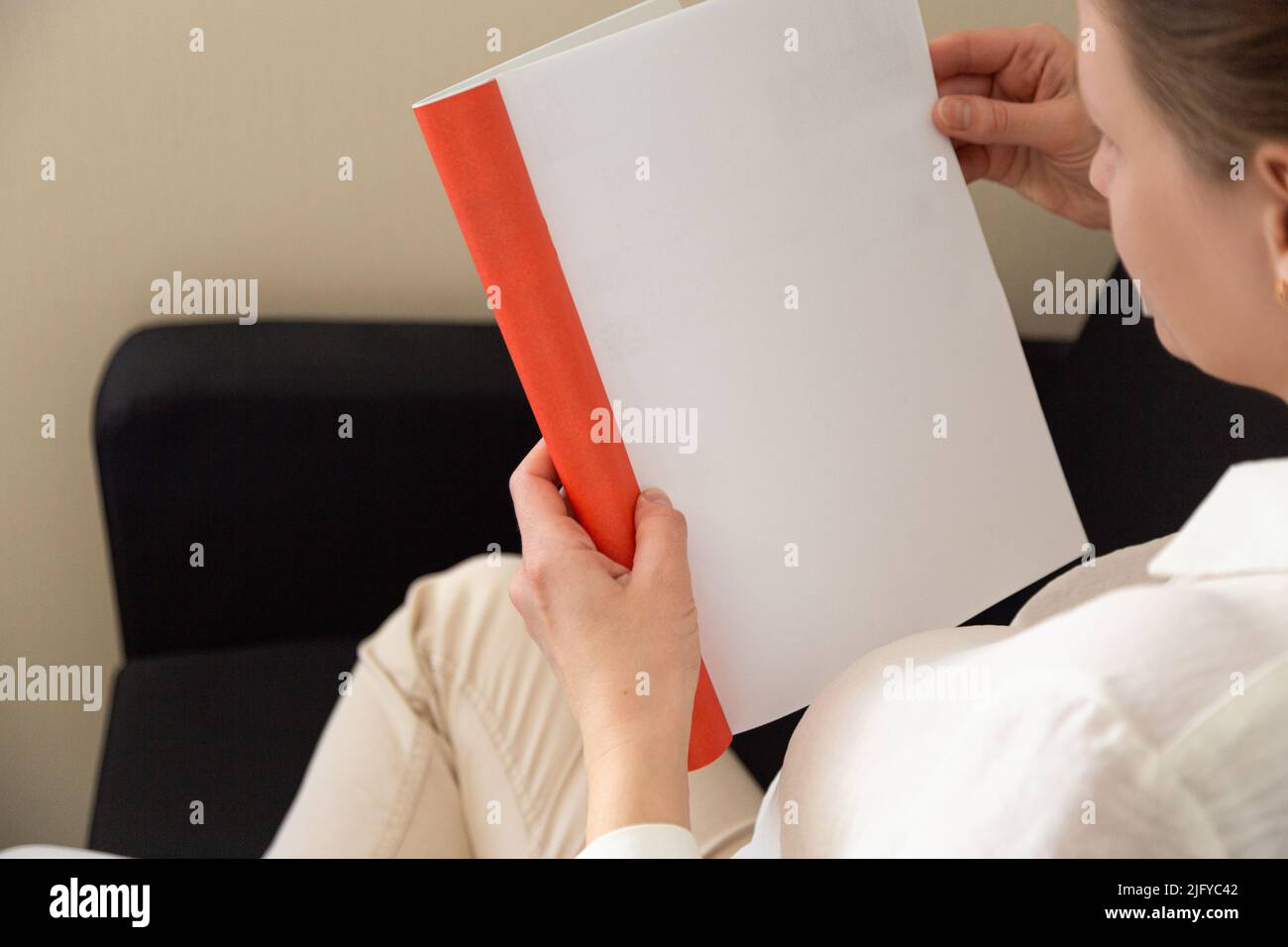 Die Hand hält ein weißes Magazin mit leerem Deckblatt. Hand in Hemd halten klar Magazin Mockup Vorlage. A4 Buch Softcover Oberflächengestaltung. Stockfoto