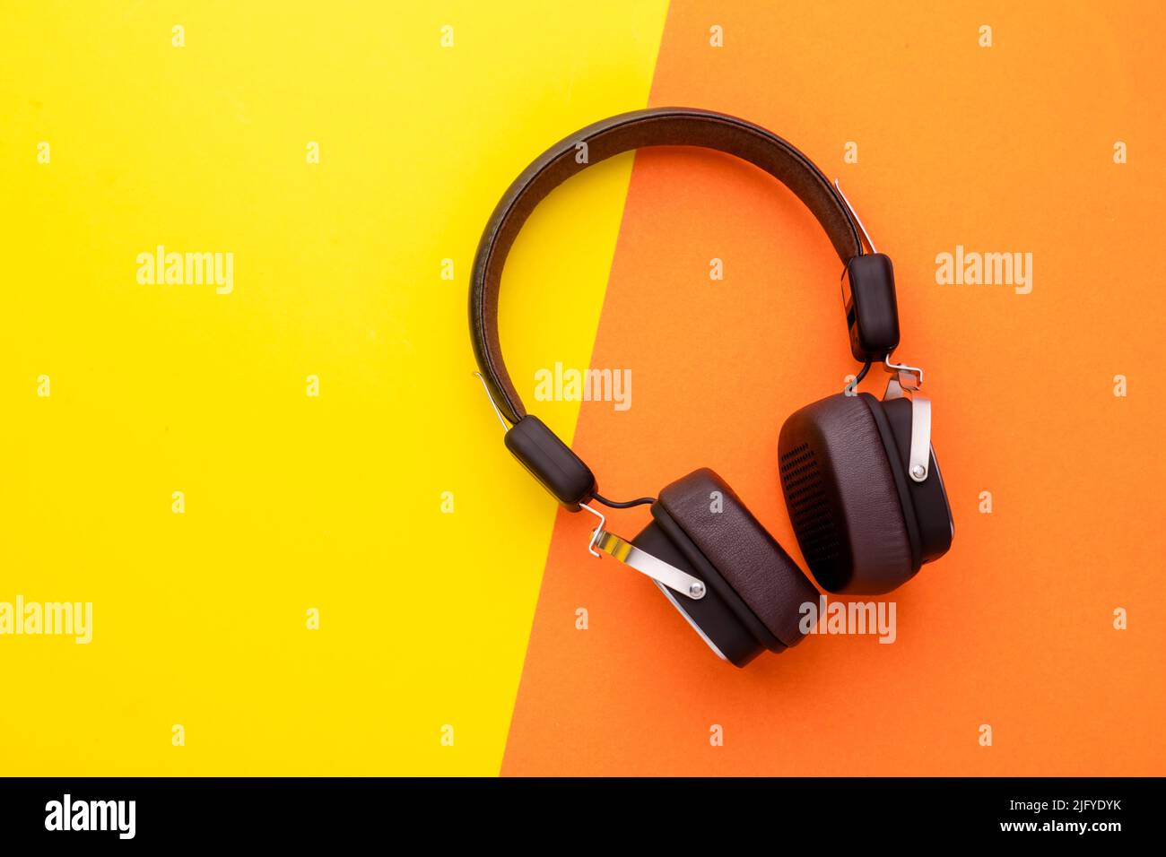 Draufsicht schwarzer Kopfhörer oder Headset auf hellem Farbhintergrund. Platz für Text oder Design kopieren Stockfoto