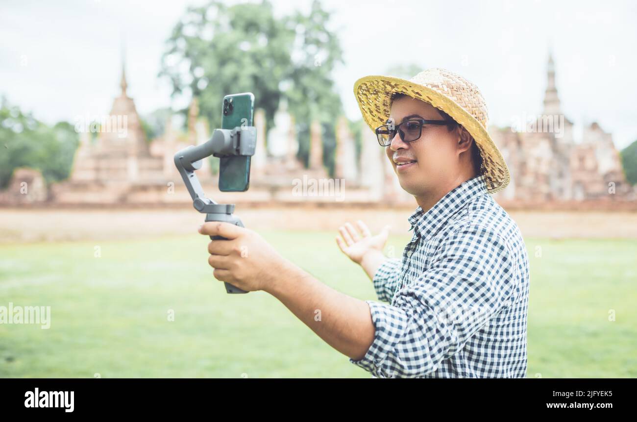 Asiatischer Tourist, der im Sukhothai Historical Park, Thailand, arbeitet und einen Laptop benutzt. Urlaubs- und Urlaubskonzept Stockfoto
