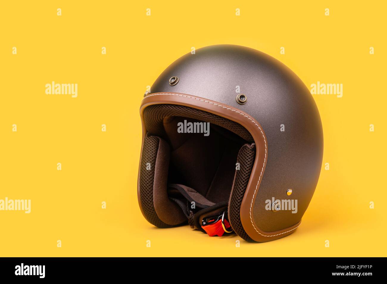 Nahaufnahme des neuen grauen Vintage-Helms. Studioaufnahme isoliert auf gelbem Hintergrund Stockfoto