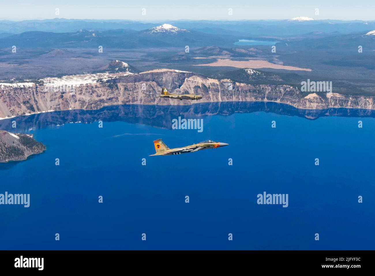 Klamath Falls, Oregon, USA. 24.. Juni 2022. Ein F-15-Adler der US-Luftwaffe aus dem 173.-Kampfflügel mit einer Lackierung zum Gedenken an den Namensgeber von Kingsley Field, LT. David R. Kingsley, fliegt in Formation mit einer B-17 Flying Fortress über Crater Lake, Oregon, während des Sentry Eagle 2022, Juni 24. Kingsley war bombardier auf einer B-17 während des Krieges und opferte sein Leben, um weitere Besatzungsmitglieder zu retten und erhielt anschließend die Ehrenmedaille. Quelle: U.S. National Guard/ZUMA Press Wire Service/ZUMAPRESS.com/Alamy Live News Stockfoto