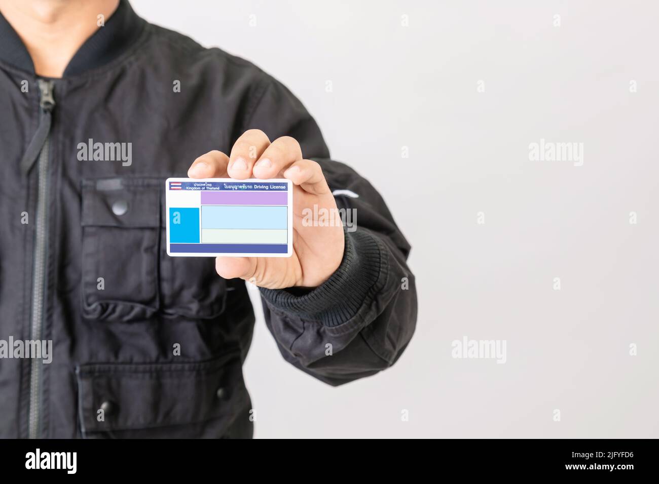 Portrait Fahrer in schwarzer Jacke halten und zeigen leere Thailand Führerschein. Über 400cc Motorräder in Thailand benötigen vor allem Lizenz. Studioaufnahme Stockfoto