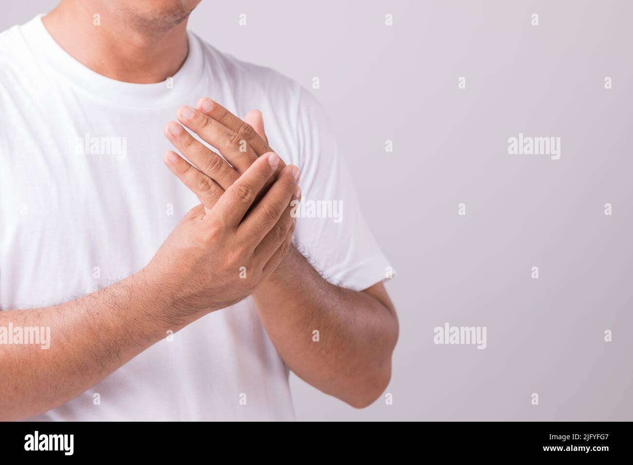 Palm Pain Concept : Nahaufnahme Mann berühren Handfläche und das Gefühl, einen Schmerz. Studio-Aufnahme isoliert auf grauem Hintergrund mit Platz für Text Stockfoto