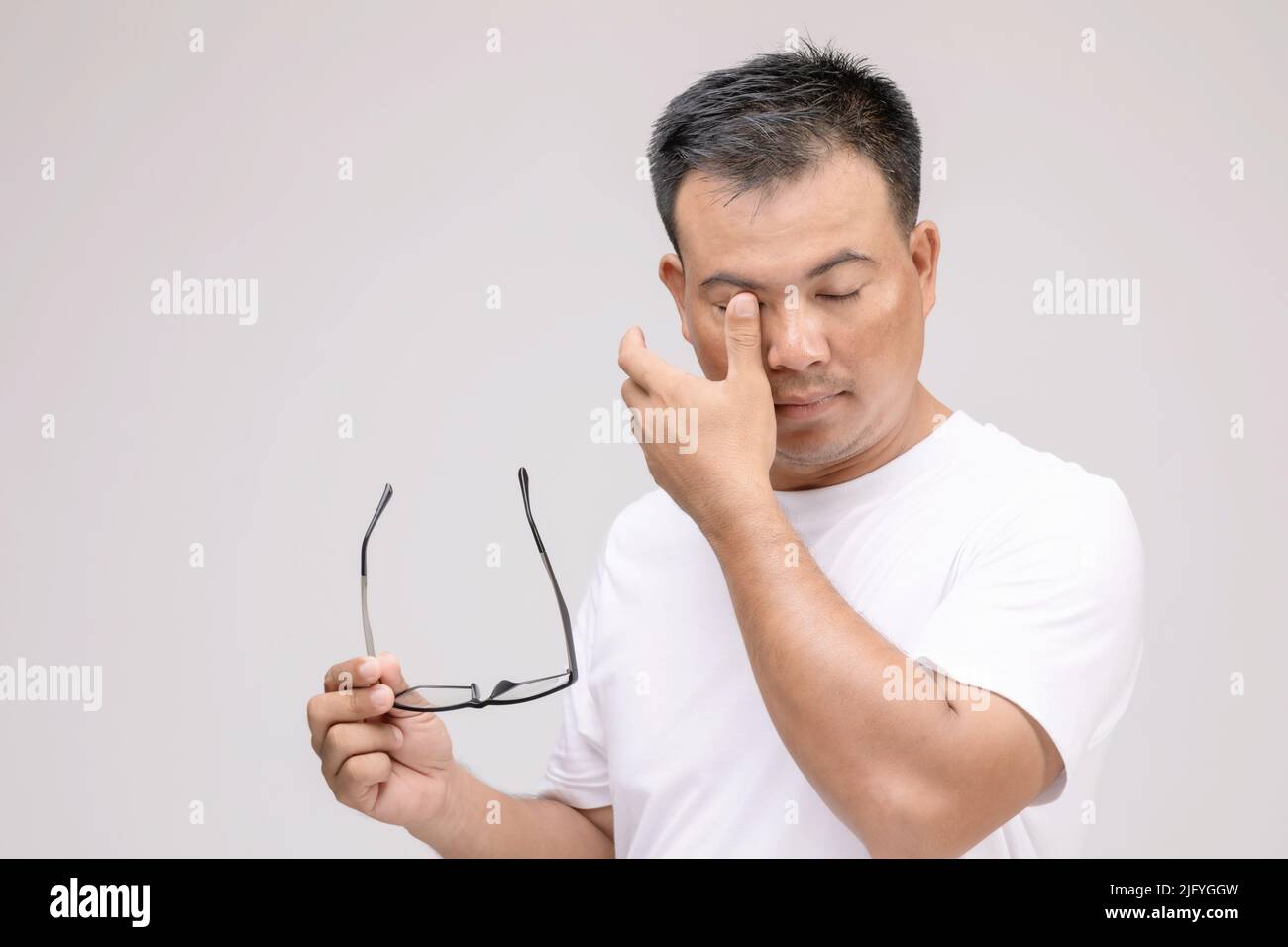 Augenreizung Konzept : Porträt des asiatischen Mannes in der Haltung der Augen müde, Reizung oder Problem über sein Auge. Studioaufnahme isoliert auf grauem Hintergrund Stockfoto