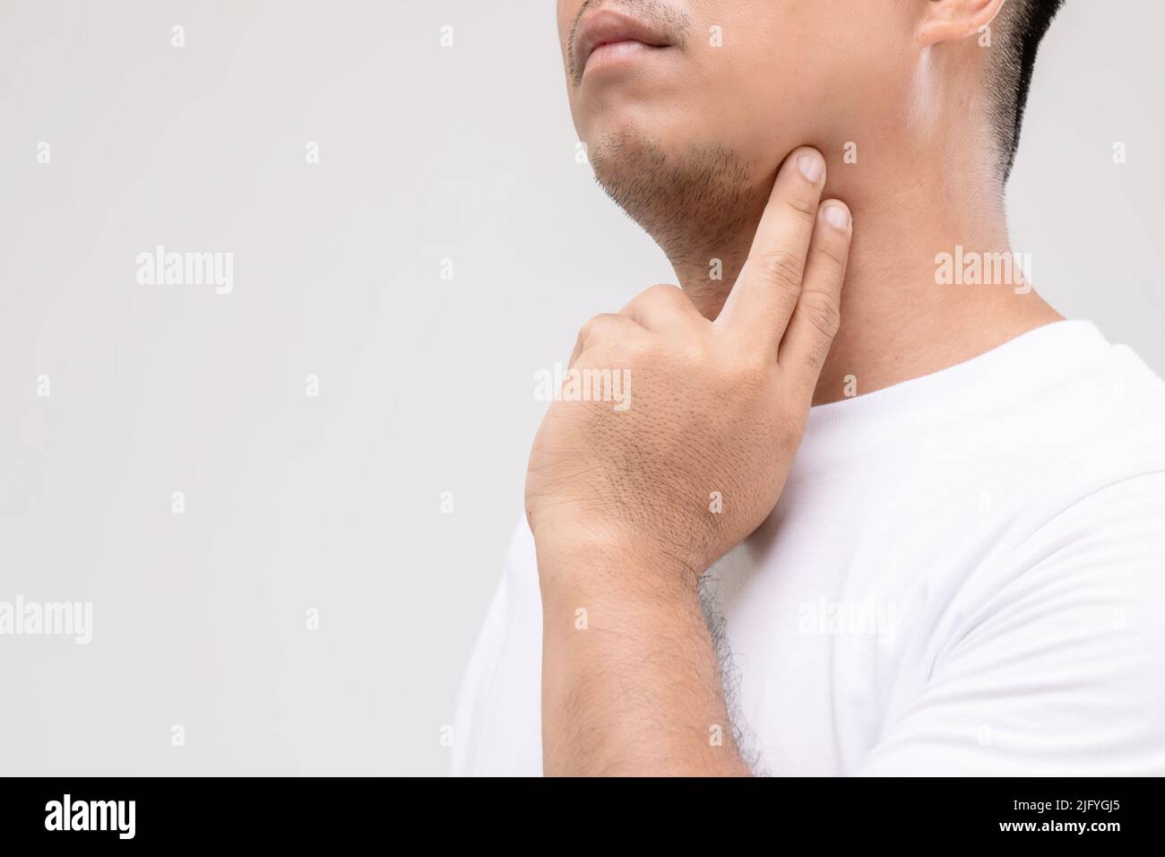 Lymphom bei Männern Konzept : Portrait asiatischen Mann ist auf seinem Hals an Lymphknoten Position berühren. Studioaufnahme isoliert auf grauem Hintergrund Stockfoto