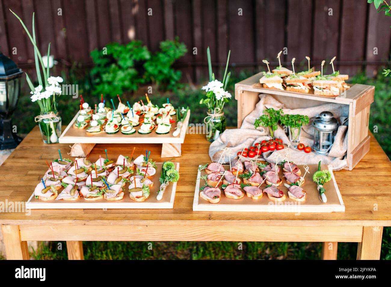 Köstliches Catering-Bankettbuffet im rustikalen Stil im Garten. Verschiedene Snacks und Sandwiches. Im Freien. Stockfoto