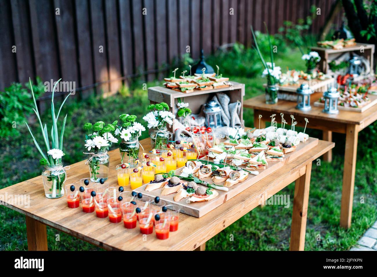 Schöne catering Bankett Buffet im rustikalen Stil im Garten eingerichtet. Verschiedene Snacks, Sandwiches und Cocktails. Outdoor. Stockfoto
