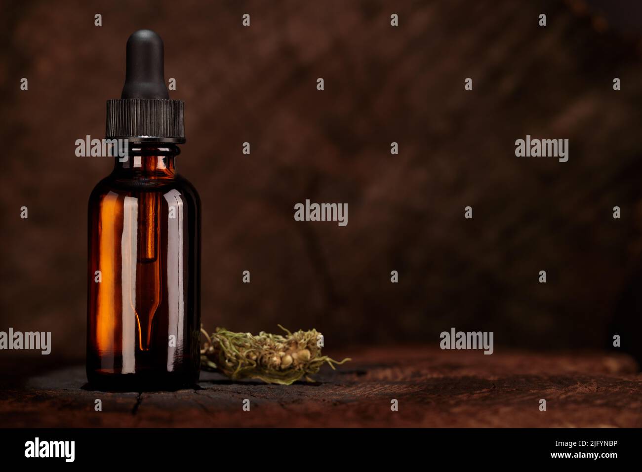 Nachbau einer Flasche mit Tropf, CBD-Öl zur Produktpräsentation. Aufnahme aus Augenhöhe, vorne. Alte Holzplatte. Alternative Medizin, konzeptuelle imag Stockfoto