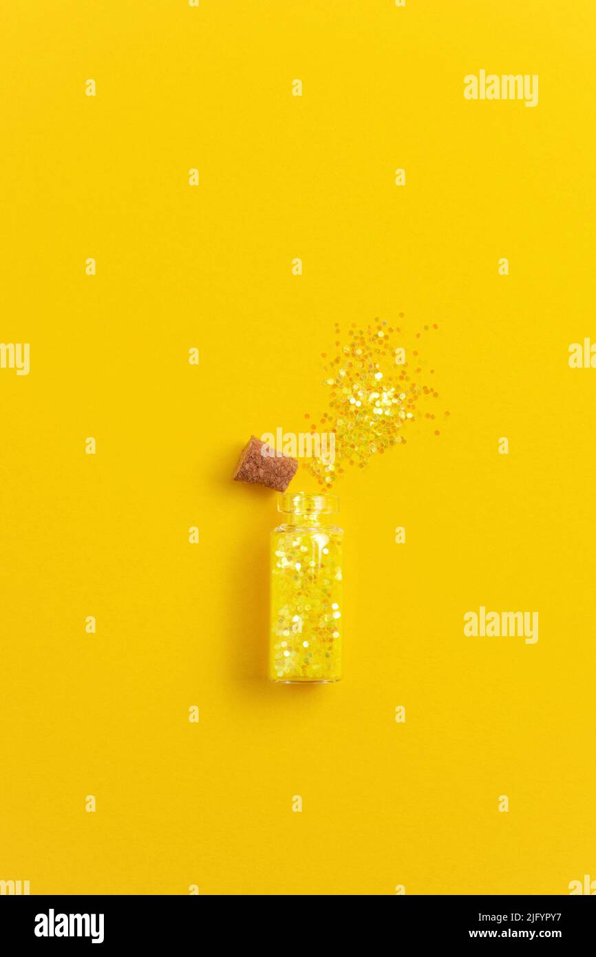 Gelbes Glitzerrohr auf gelbem Hintergrund. Party-Konzept, Kopierraum. Stockfoto