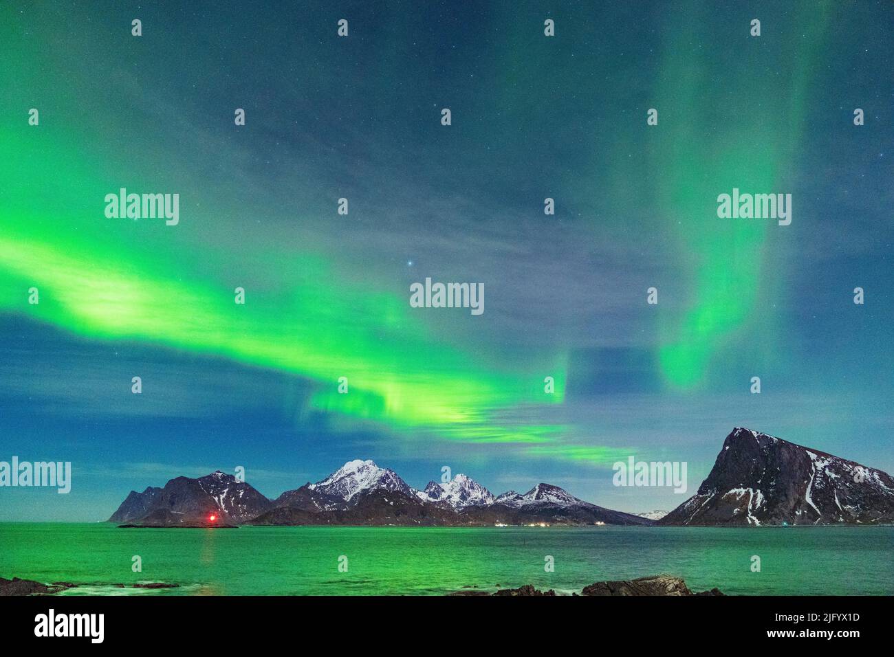 Sternenhimmel mit Aurora Borealis (Nordlichter) über Bergen und kaltem Meer, Myrland, Leknes, Vestvavoy, Lofoten-Inseln, Norwegen, Skandinavien Stockfoto