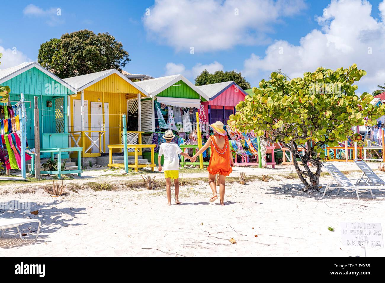 Mutter mit einem kleinen Jungen, der sich die bunten Strandhütten mit Souvenirs ansieht, Antigua, Leeward Islands, Westindien, Karibik, Mittelamerika Stockfoto