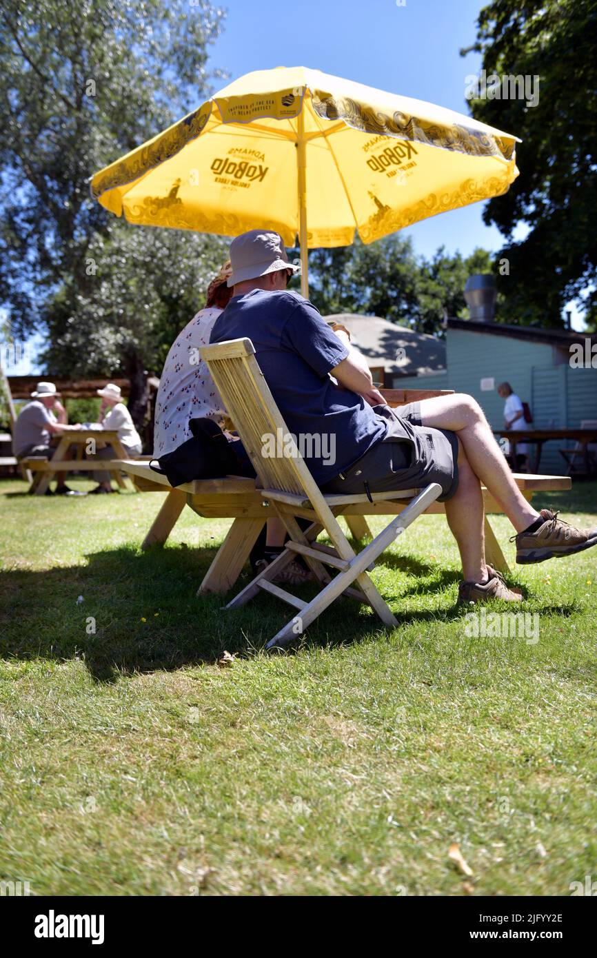 Ein Paar sitzt unter dem Sonnenschirm Stockfoto