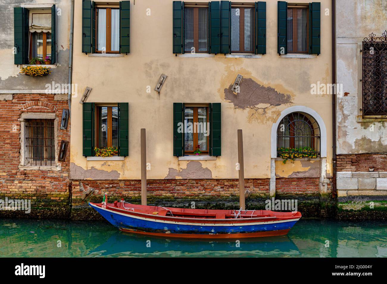Ein leeres rot-blaues Boot, das in Rio della Misericordia, Venedig, UNESCO-Weltkulturerbe, Venetien, Italien, Europa, festgemacht ist Stockfoto