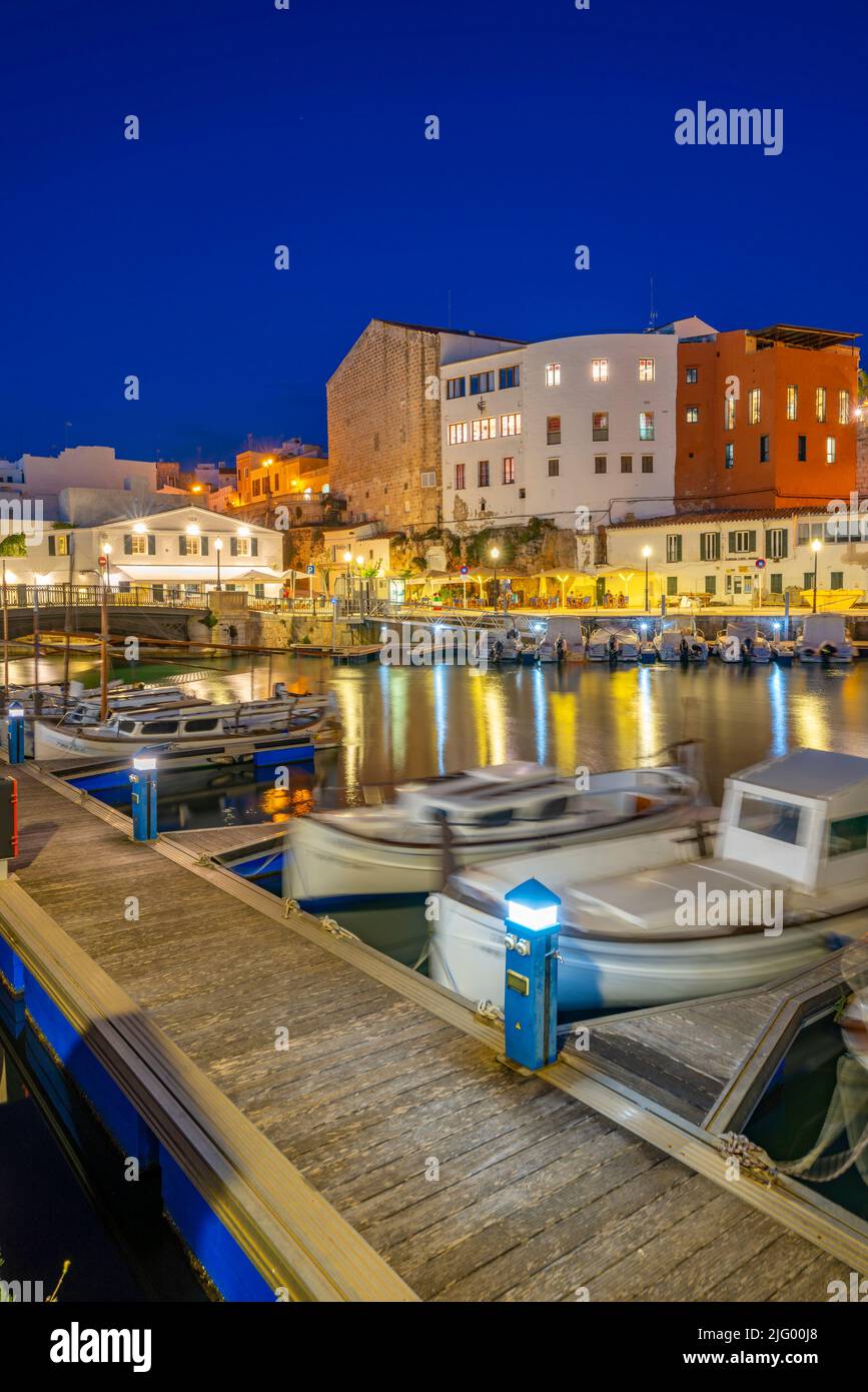 Blick auf Boote in der Marina, die in der Abenddämmerung von weiß getünchten Gebäuden überblickt werden, Ciutadella, Menorca, Balearen, Spanien, Mittelmeer, Europa Stockfoto
