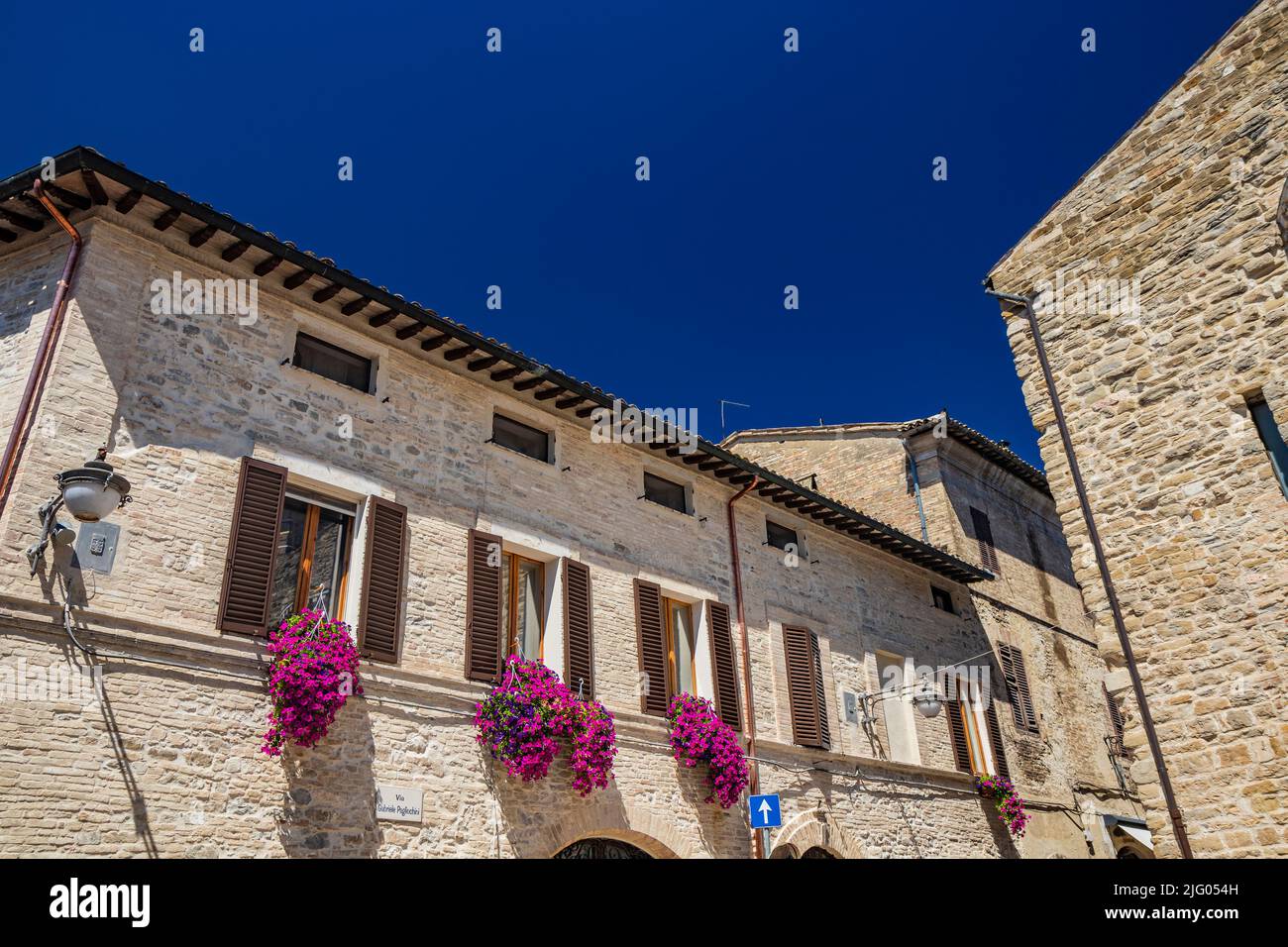 19. Juni 2022 - Perugia, Umbrien, Italien. Ein Blick auf das mittelalterliche Dorf Bevagna. Die alten Gebäude aus Stein und Ziegel, mit schönen Magenta Stockfoto