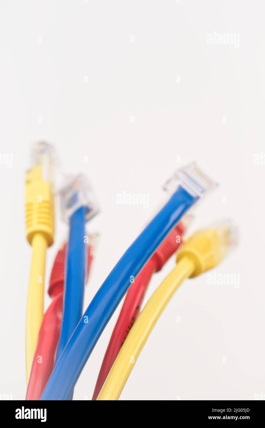 gigabit-Netzwerkkabel mit RJ45 Anschlüssen auf einer hellen weißen Tischoberfläche Stockfoto