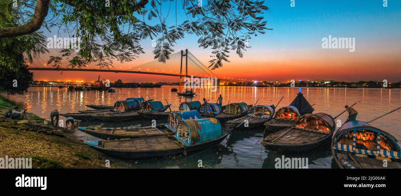 Kalkutta, 18, März, 2013; Panoramablick auf die Vidyasagar Setu Brücke und lokale Boote mit Reflexionen im Fluss Hooghly in der Dämmerung, Kalkutta, West Bengal, I Stockfoto