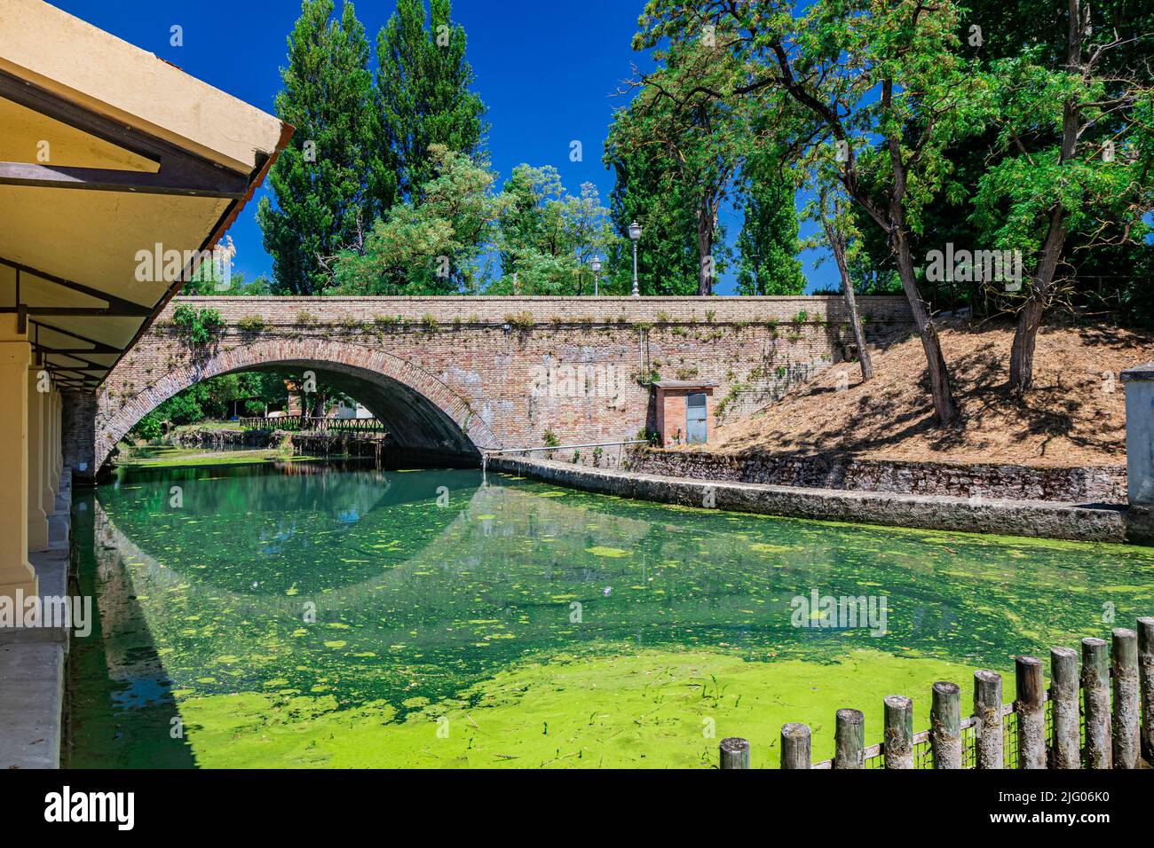 Das alte Waschhaus und die gemauerte Brücke über den Fluss, im mittelalterlichen Dorf Bevagna. Perugia, Umbrien. Blauer Himmel an einem sonnigen Sommertag. Gre Stockfoto