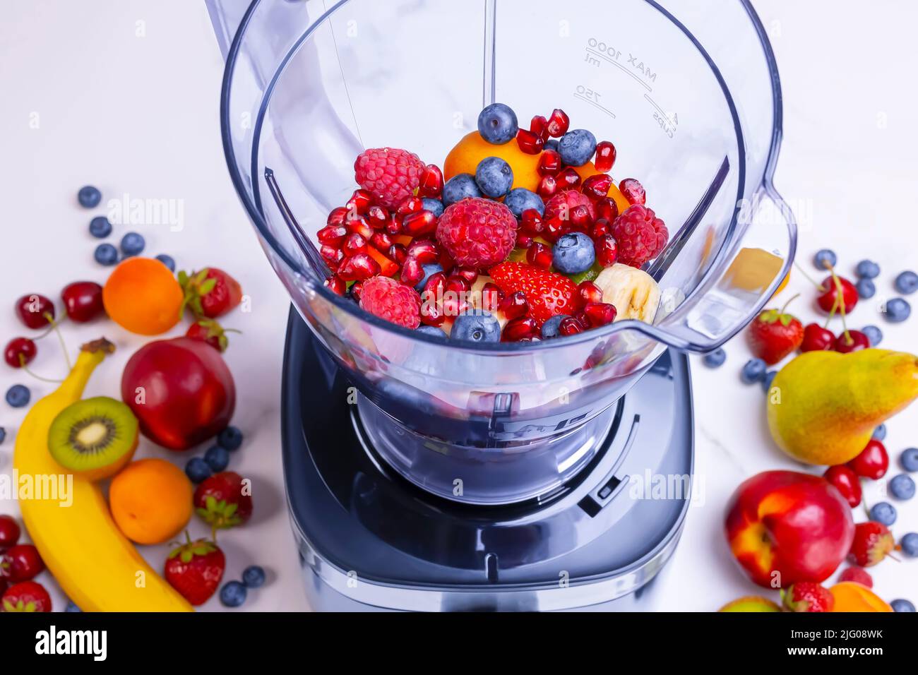 Frischer Obst-Smoothie im Mixer. Vorbereitung eines frischen Getränks voller Vitamine für eine gesunde Ernährung. Stockfoto
