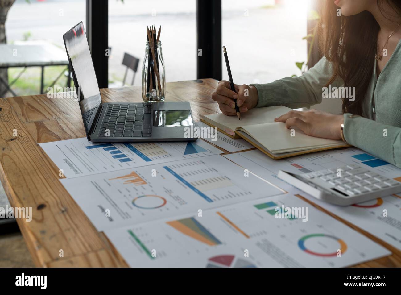 Business Frau arbeiten mit finanziellen Daten Hand mit Rechner und Schreiben Notiz mit rechnen. Business Finanz-und Rechnungswesen Konzept. Stockfoto