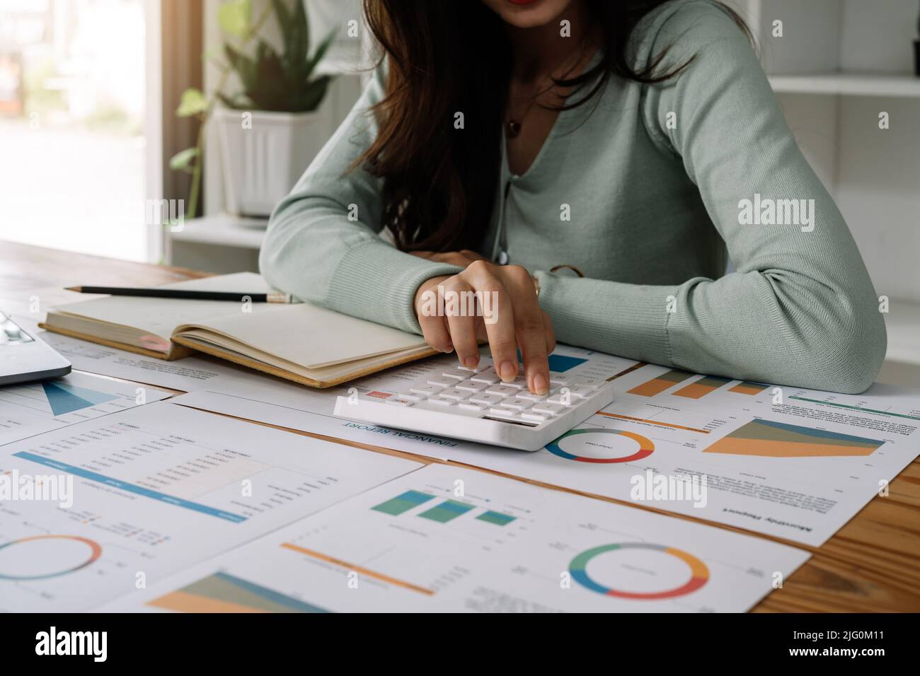 Business Frau arbeiten mit finanziellen Daten Hand mit Rechner und Schreiben Notiz mit rechnen. Business Finanz-und Rechnungswesen Konzept. Stockfoto