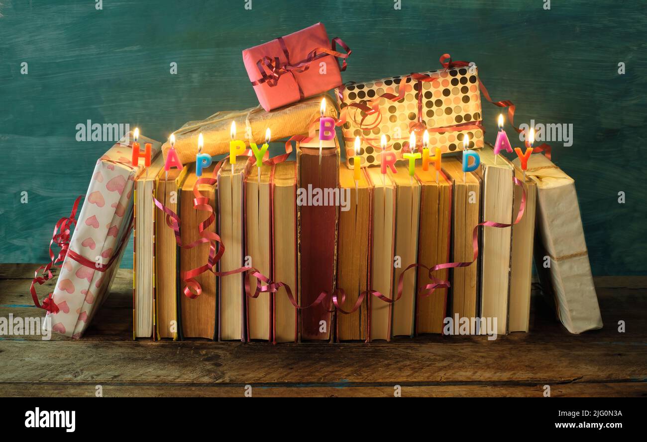 Bücher als Geburtstagsgeschenk, Reihe von Büchern, Geburtstagskerzen, Geschenk verpackt Bücher, Literatur, Lesen und Bildungskonzept. Stockfoto