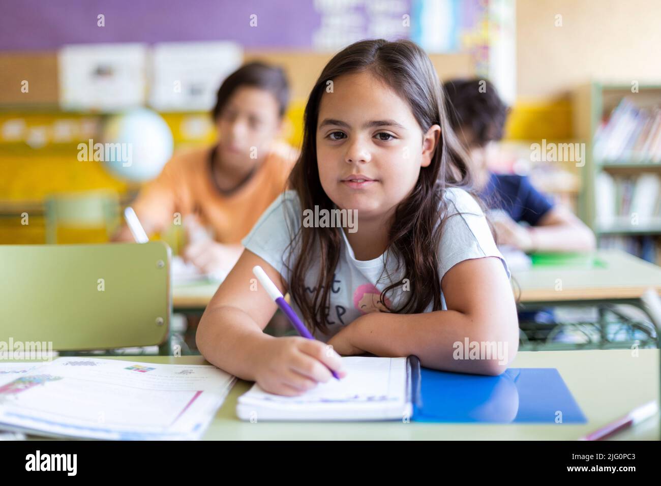 Kaukasisches kleines Mädchen, das sich im Unterricht Notizen gemacht hat. Konzept des Lernens, der Bildung und der Entwicklung im Kinderalter. Zurück zur Schule. Stockfoto