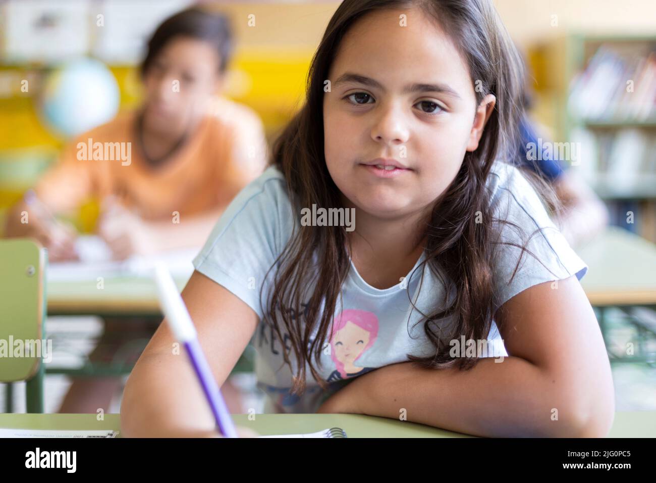 Nahaufnahme eines kleinen kaukasischen Mädchens während einer Schulklasse. Konzept des Lernens, der Bildung und der Entwicklung im Kinderalter. Stockfoto