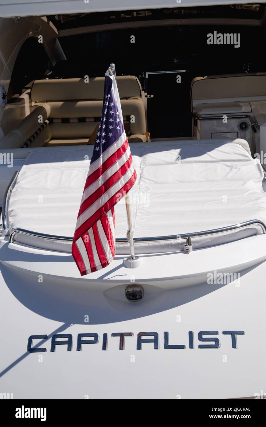 Stern einer Luxus-Motoryacht namens Capitalist und am Heck Mitarbeiter getragen die USA Ensign eine große Sterne und Streifen amerikanischen Flagge in Newport Beach USA Stockfoto