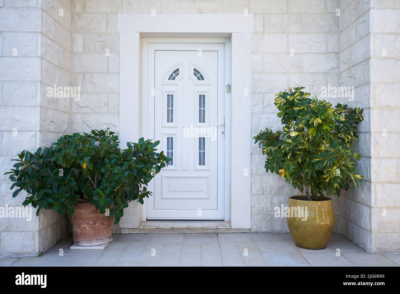 Weiße Kunststoff-Eingangstür und Fassade Dekorationen mit Pflanzen. Stockfoto