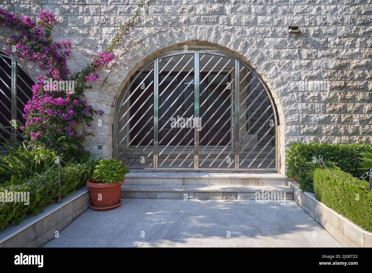 Bogen in einem Gebäude mit einem eleganten Gitter vor Tür. Stockfoto