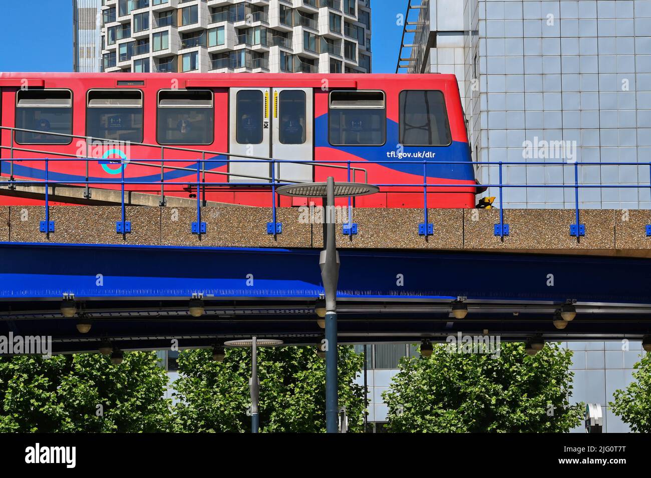 London, England - 2022. Juni: Zug auf der Docklands Light Railway auf einer erhöhten Strecke Stockfoto