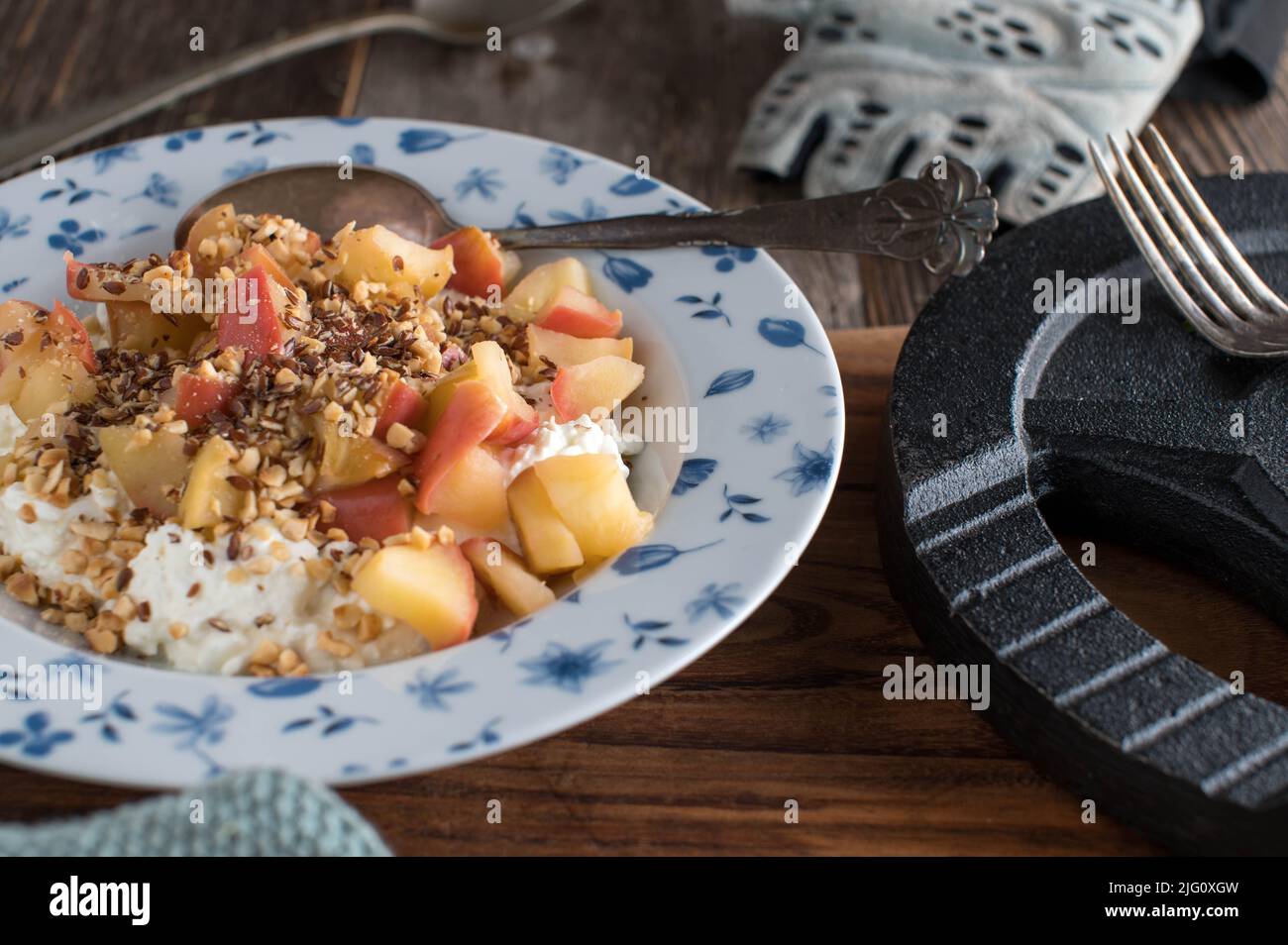 Bodybuilding-Frühstück mit proteinreichem Hüttenkäse, gekochten Äpfeln, gerösteten Haselnüssen und Leinsamen Stockfoto