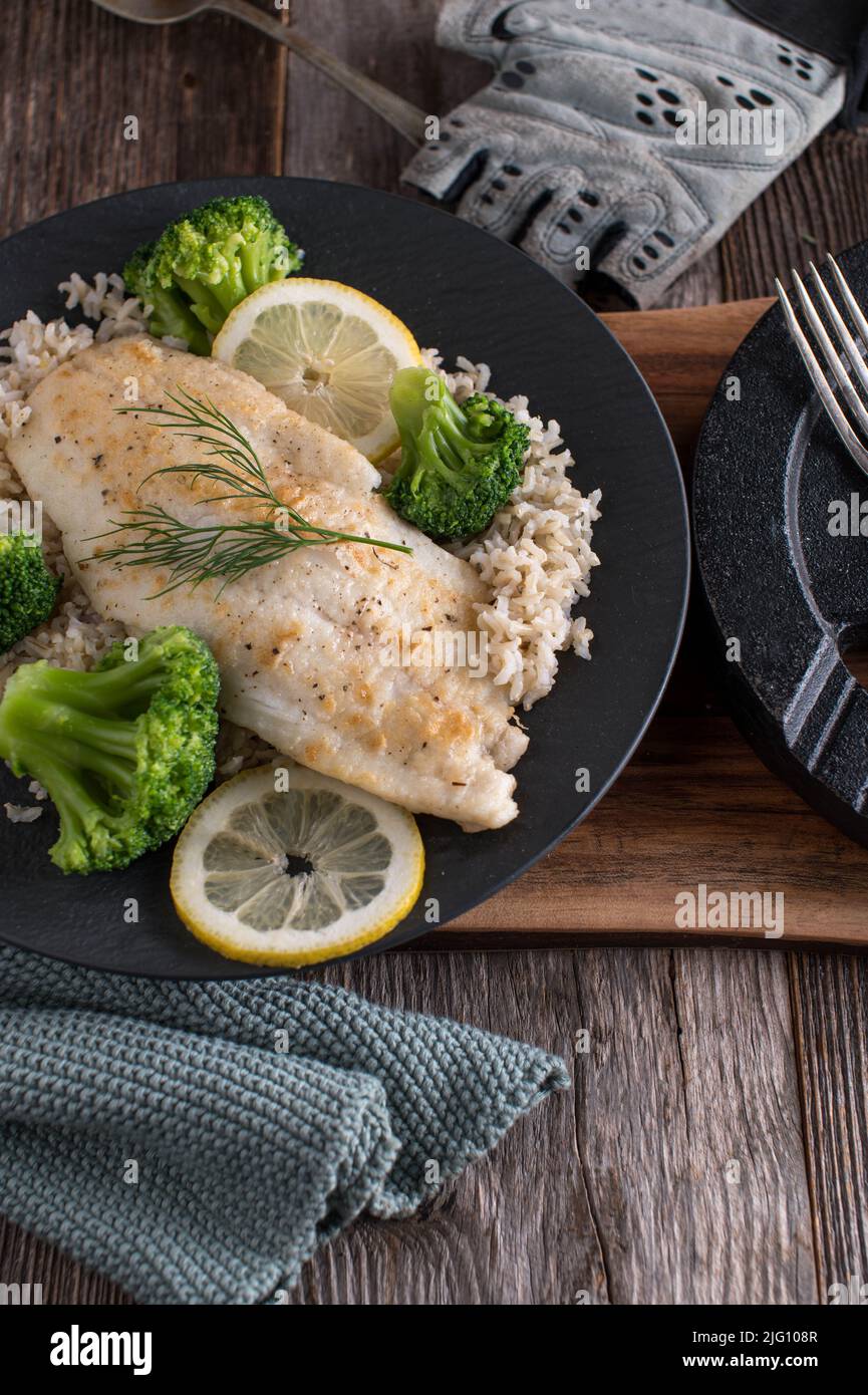 Körperaufbauende Mahlzeit mit proteinreichem, angebratenen Fischfilet, braunem Reis und Brokkoli. Hausgemachte gekochte Sportnahrung Stockfoto