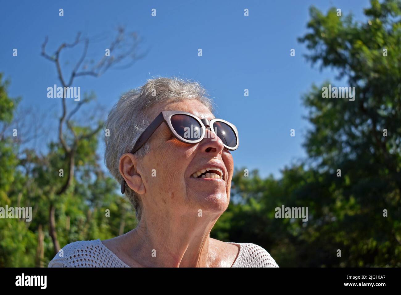 Ältere Frau, die zur Sonne schaut Stockfoto