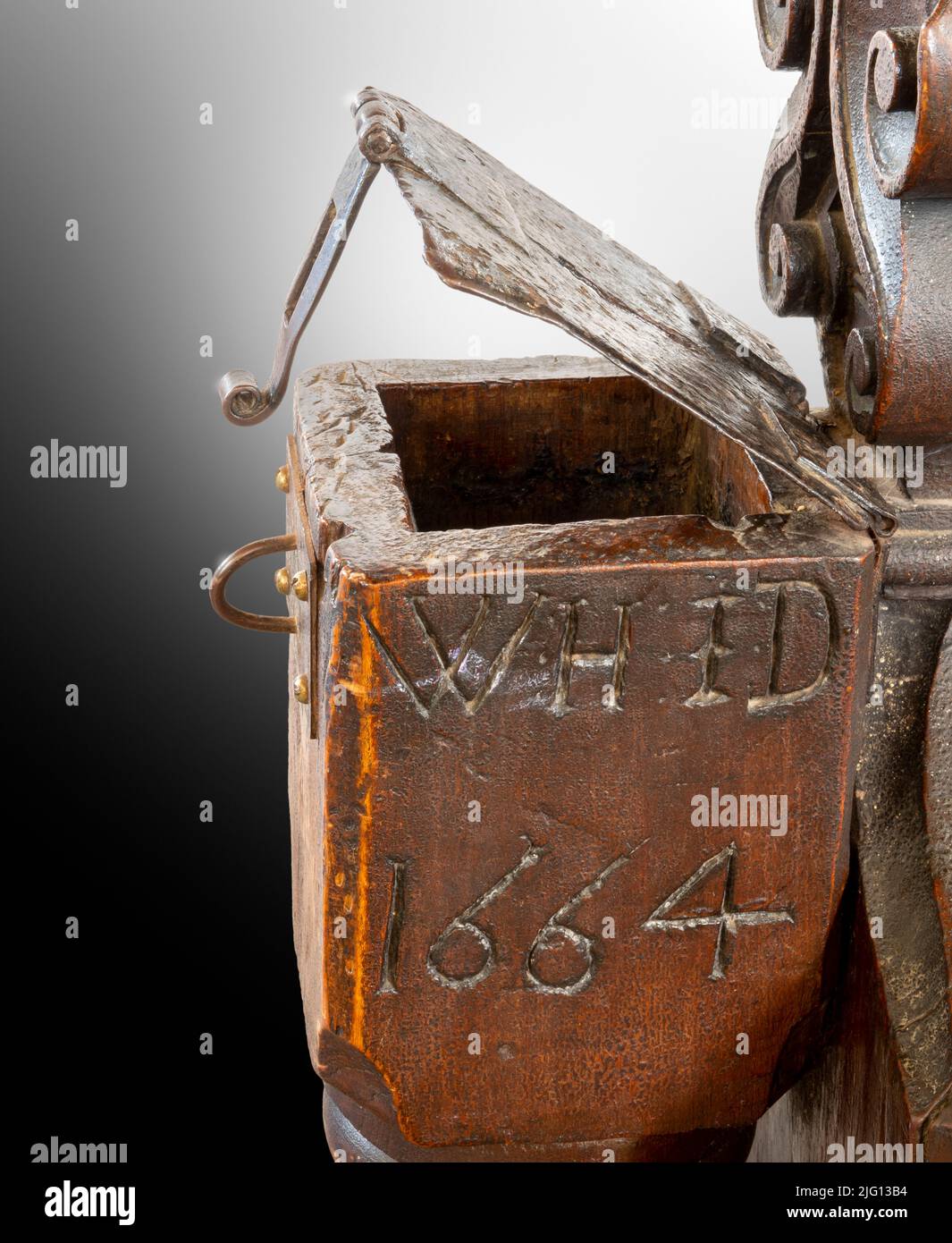 Geschnitztes Holzbankende, das eine „arme Box“ mit Metallverschluss und verschließenden Möbeln bildet, datiert 1664, All Saints, Laxfield, Suffolk Stockfoto