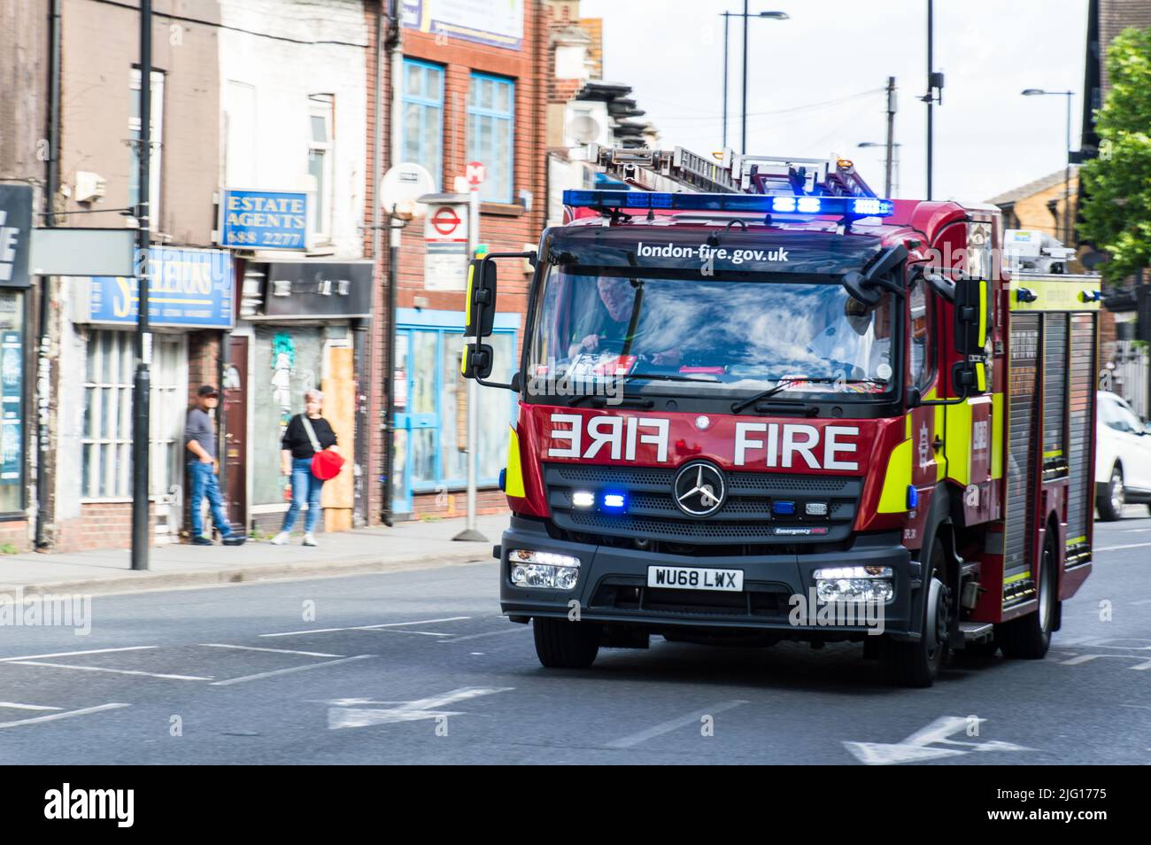 Feuerwehrmotor der Londoner Feuerwehr mit blauen Lichtern in der High Street in South London Stockfoto