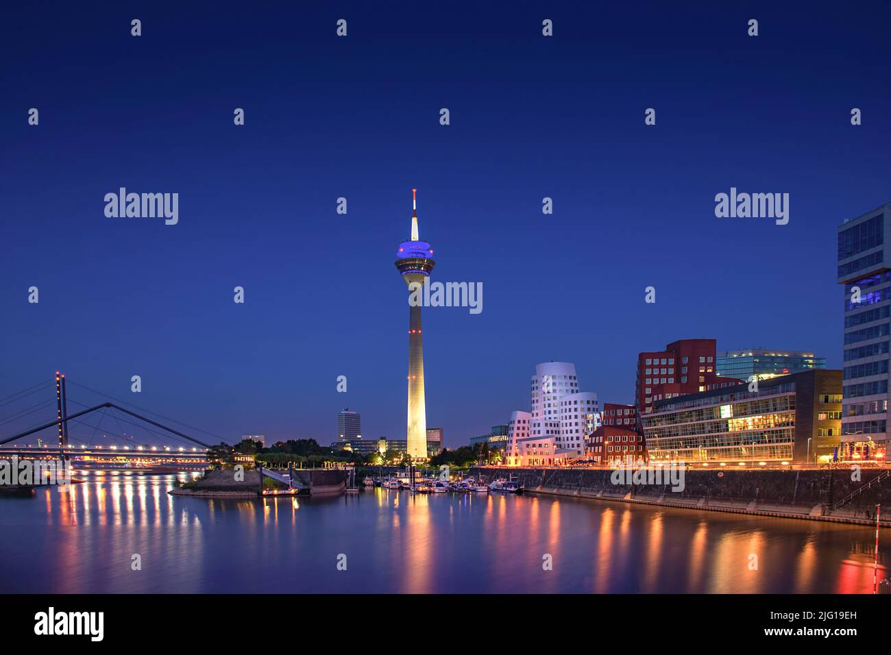 Düsseldorfer Medienhafen mit dem Fernsehturm Rheinturm und den berühmten Gehry-Gebäuden bei Nacht Stockfoto