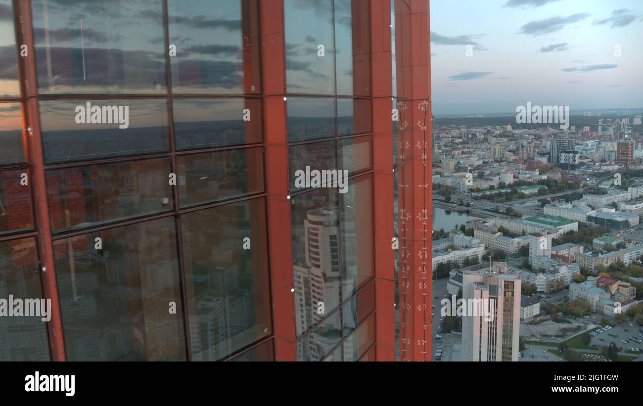 Ein langes Glasbüro.Stock Footage.der Blick von der Drohne ist auf ein riesiges Büro mit Glasfenstern und großen Gebäuden in der Umgebung und man kann die bewölkten sehen Stockfoto