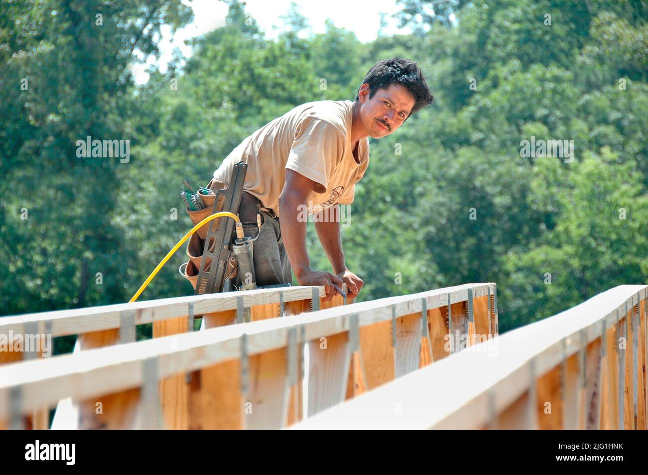 Lateinischen Belegschaft Gebäude Holzstab gebaut Haus Hause schneiden Maßnahme Nagelung an heißen Tag Stockfoto