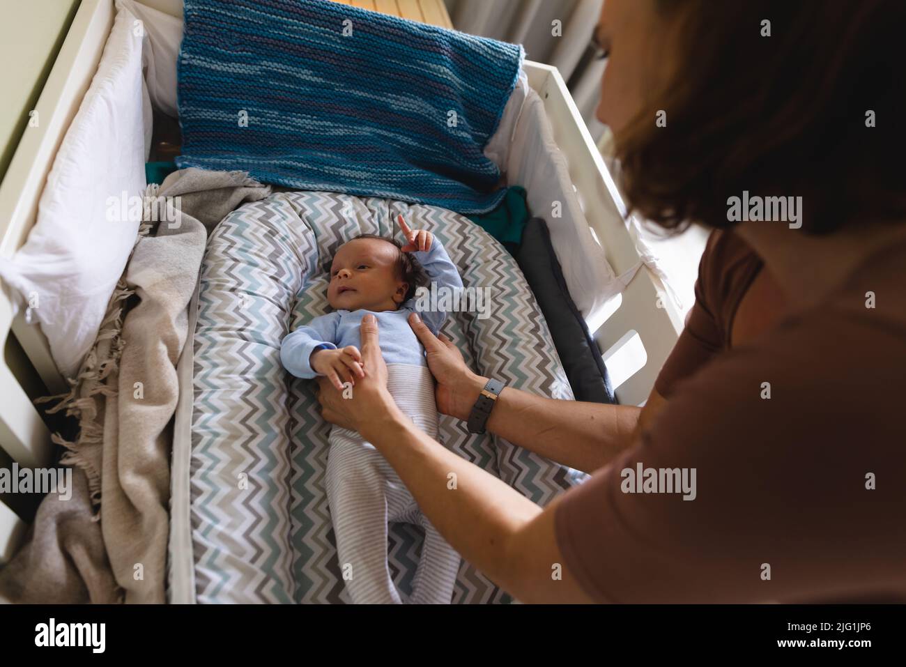 Fürsorgliche kaukasische mittlere Erwachsene Mutter hält niedliches neugeborenes Baby in der Krippe zu Hause Stockfoto