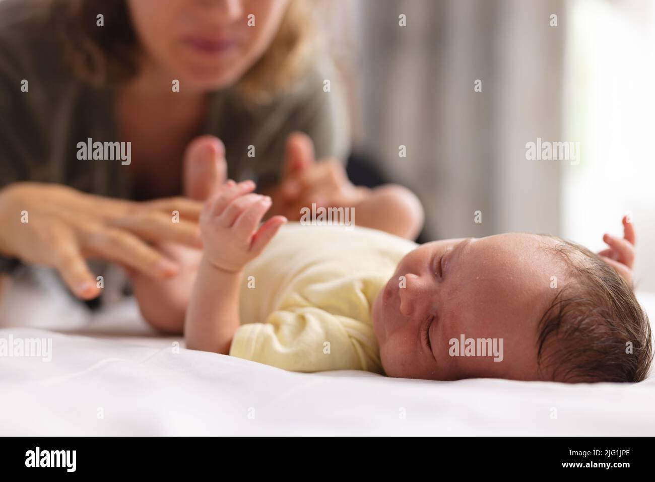 Kaukasische mittlere Erwachsene Mutter besucht niedlichen Neugeborenen schlafen Baby auf dem Bett zu Hause, Platz kopieren Stockfoto