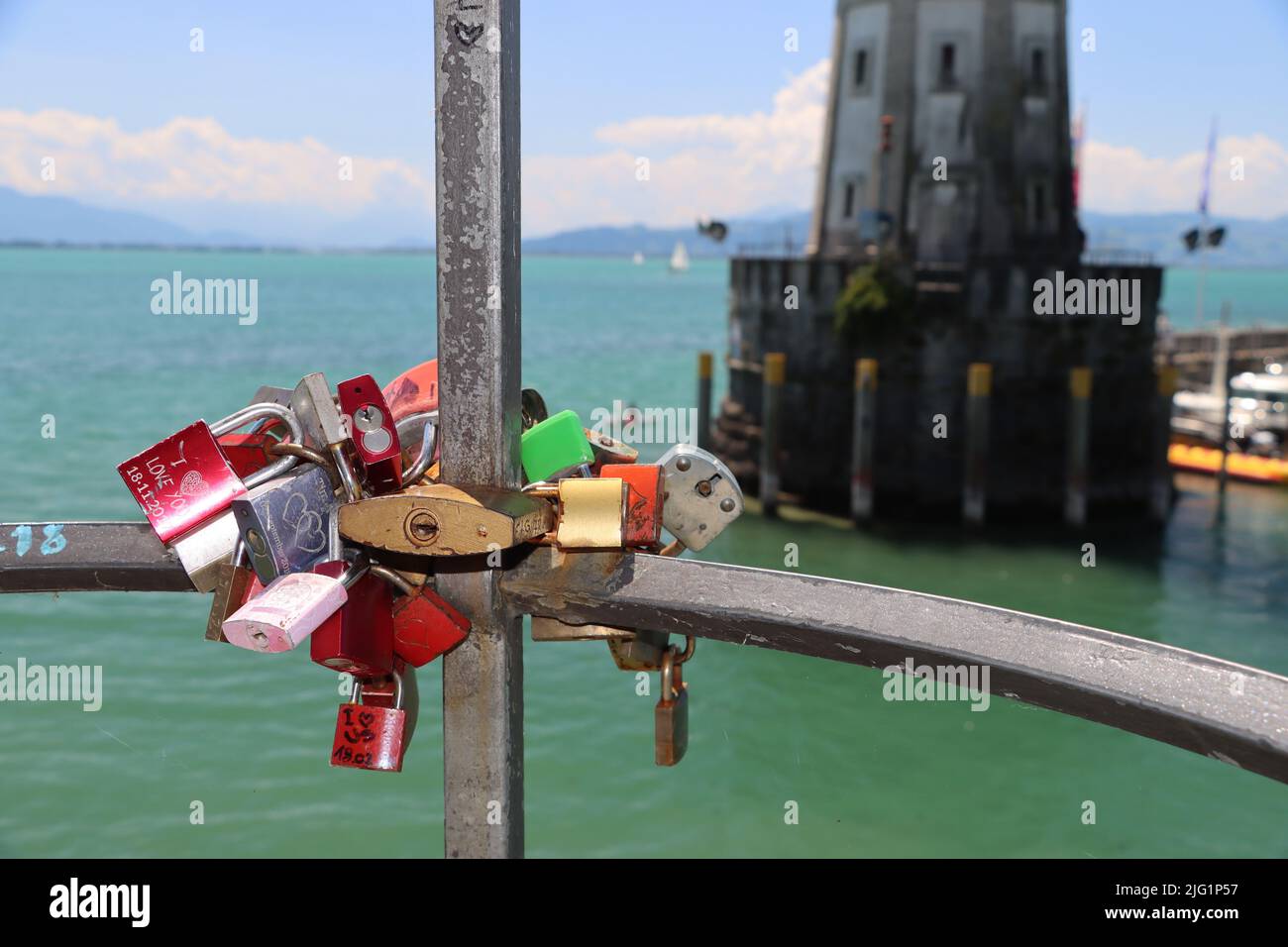 Wie moderne Kunst - Blockschloss am Hafeneingang in Lindau mit Hintergrund von Lichtmaschine - Hafeneingang im Sommer. Erinnerung an Flitterwochen & Romantik. Stockfoto