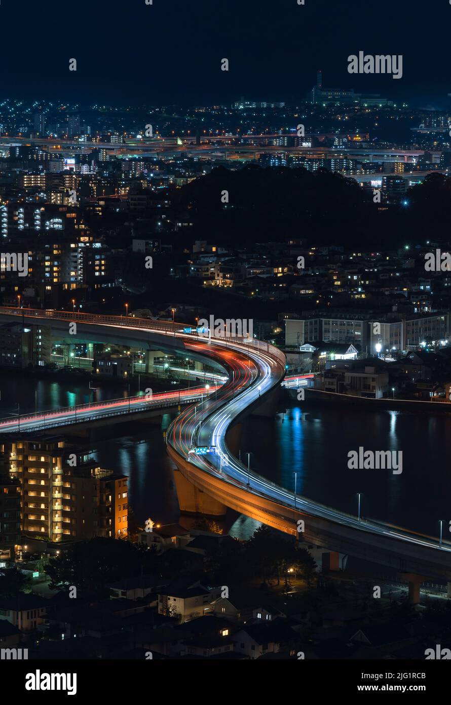 Blick aus der Vogelperspektive bei Nacht auf die beleuchtete städtische Schnellstraße, die im Zickzack den Fluss Muromi überquert, der durch die Stadt Fukuoka t führt Stockfoto