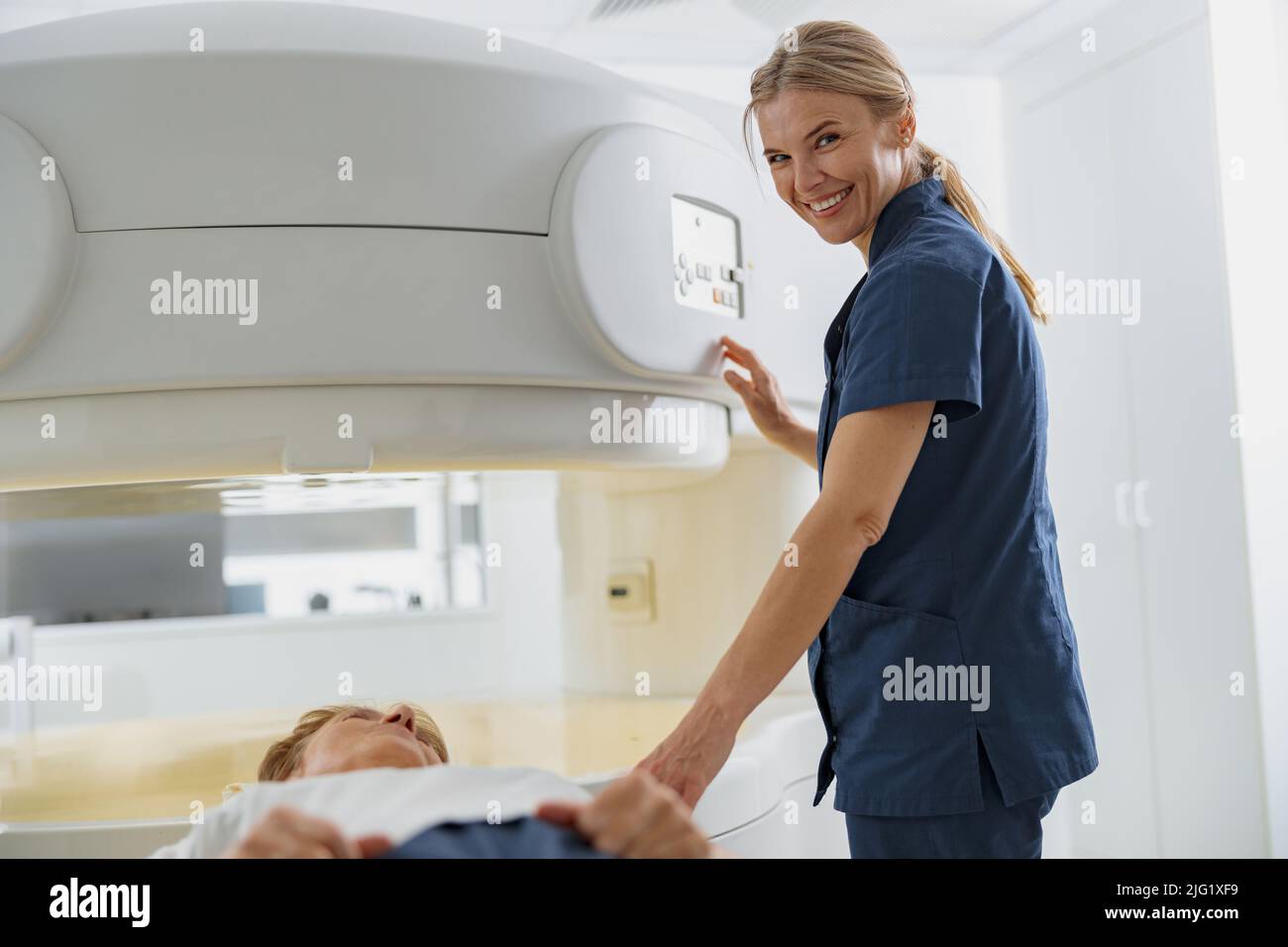 Der Radiologe steuert die MRT- oder CT- oder PET-Scans mit dem Patienten, der sich einer Untersuchung unterziehen muss, und einer Kamera, die sich im Blick befindet Stockfoto