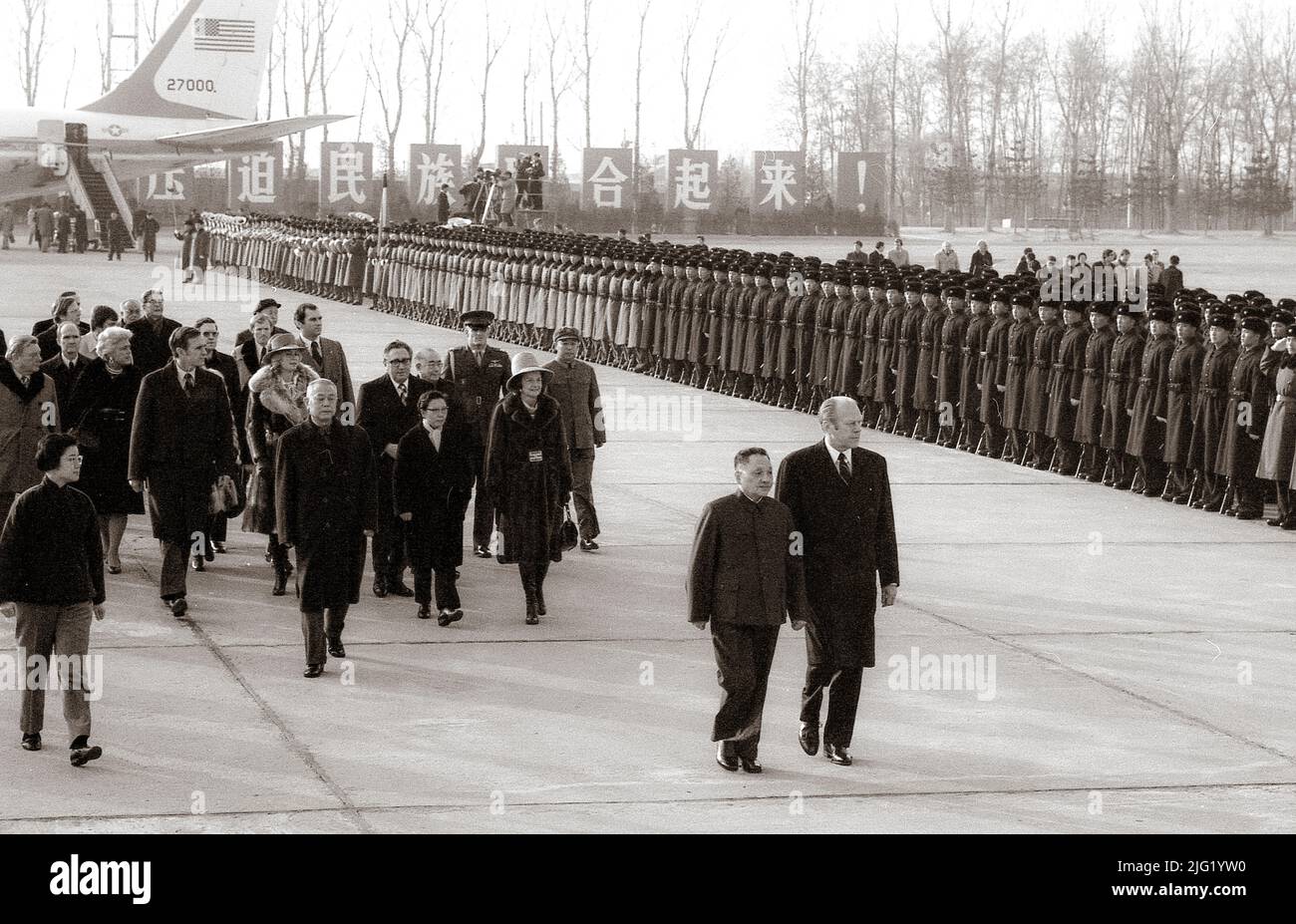 Begleitet von Deng Xiao Ping inspiziert Präsident Ford den Ehrenwächter bei seiner Ankunft in China mit seinem Gefolge, zu dem auch Frau Ford und Außenminister Henry Kissinger gehörten. 1. Dezember 1975. Stockfoto