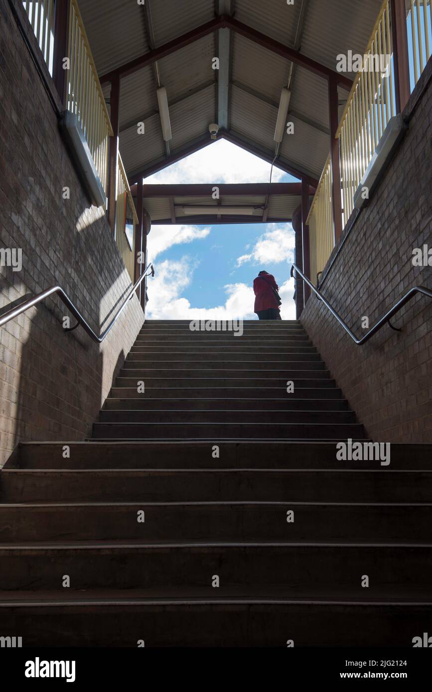 Eine silhouettierte Person, die oben auf einer verdunkelten Bahnhofstreppe in Sydney, New South Wales, Australien, steht Stockfoto