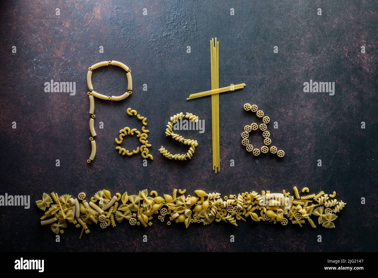 Das Wort Pasta aus Nudelnudeln, vor dunklem Hintergrund. Stockfoto