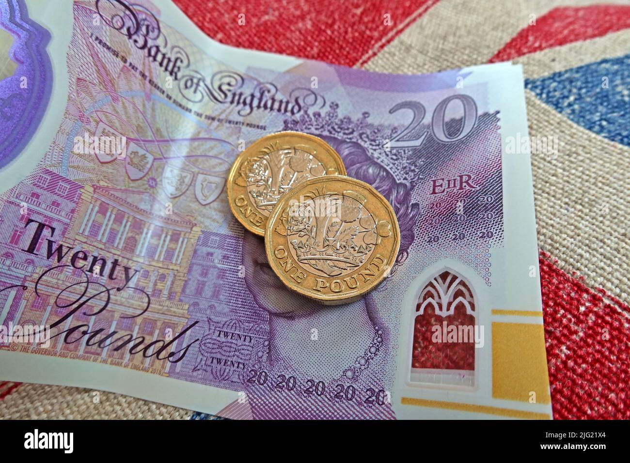 Sterling-Pfund-Scheine, Bank von England und Pfund-Münzen auf einer Gewerkschaft Jack Flagge - Lebenshaltungskosten Krise, in Großbritannien / GB Stockfoto